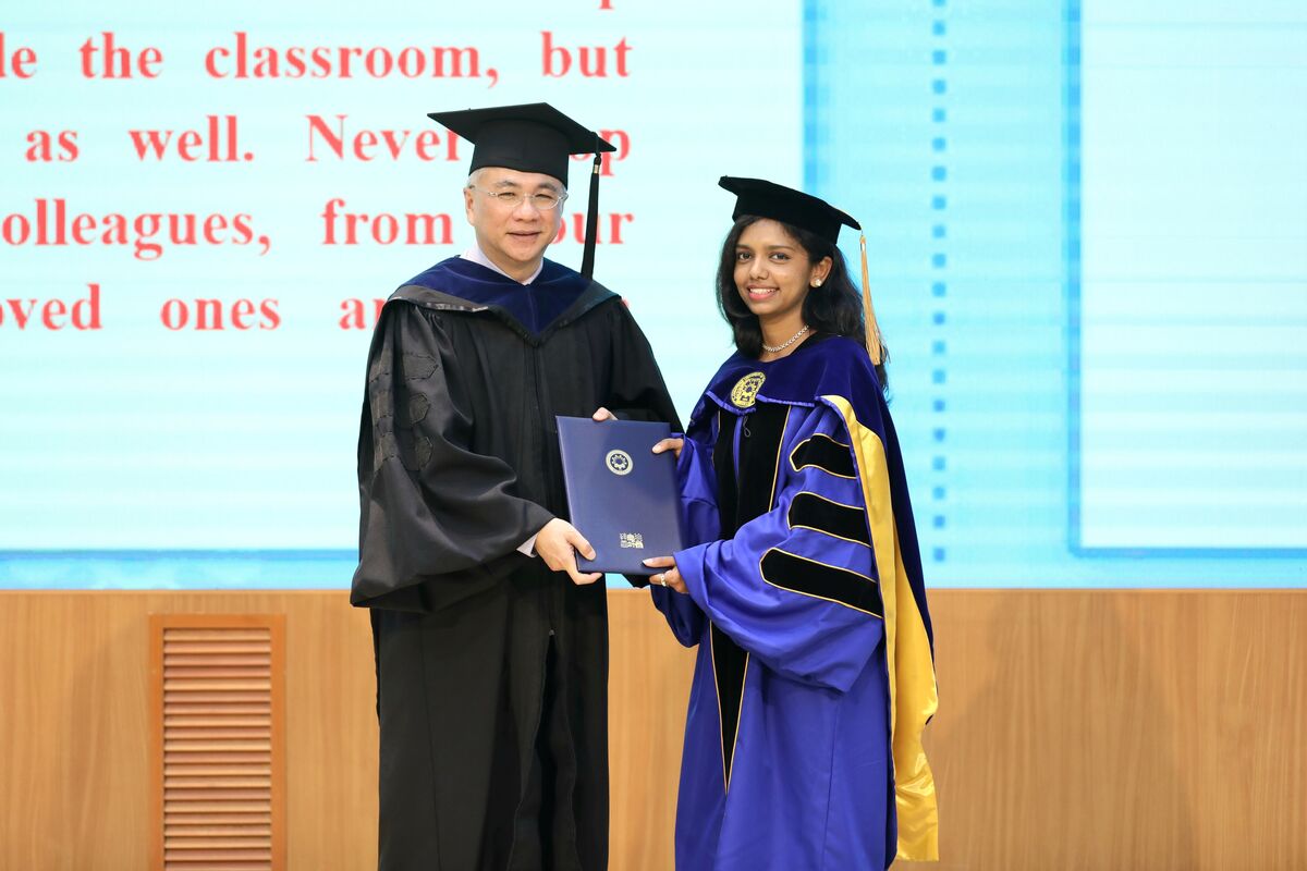 President Tao-Ming Cheng (left) awarded a doctoral degree to an international graduate.