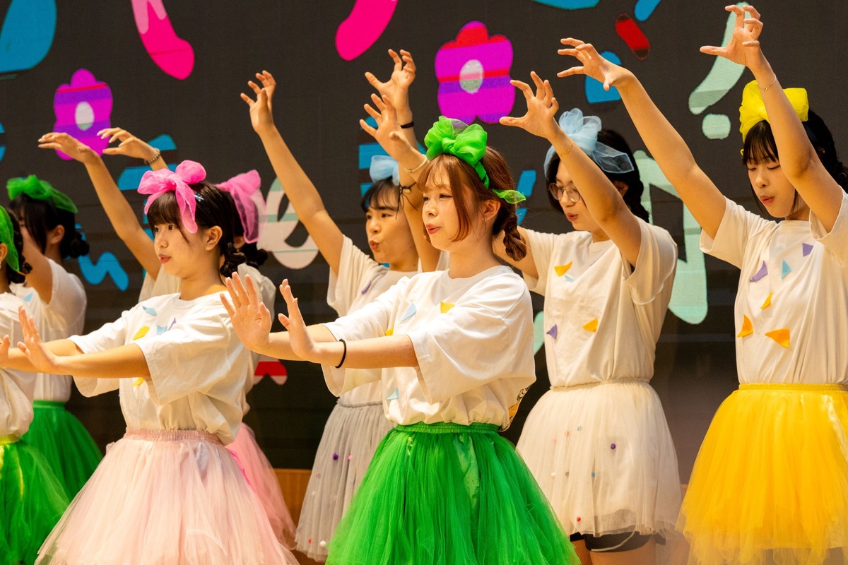 Early Childhood Development and Education students, winners of the choral competition, perform a birthday song in colorful attire.Image