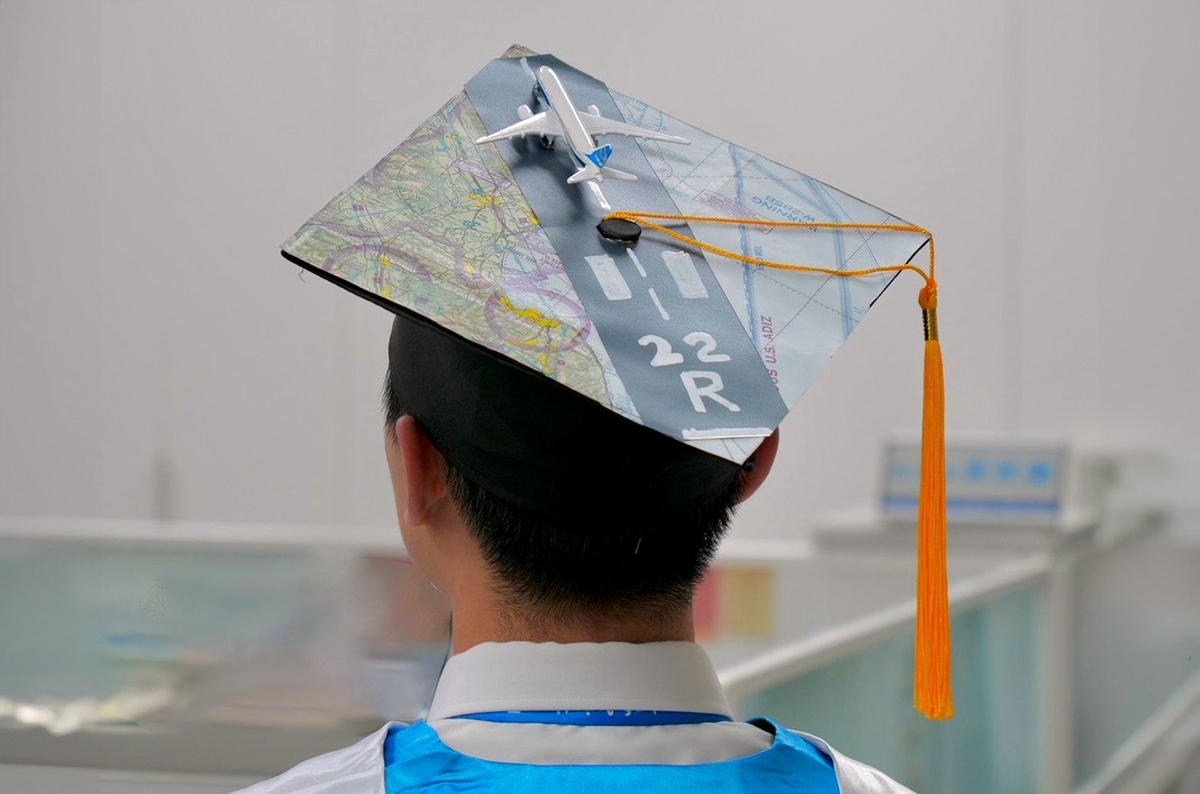 Graduate Yu-Jen Su decorated his cap with a B787-9 Dreamliner on a runway — a creative aviation-themed tribute.Image