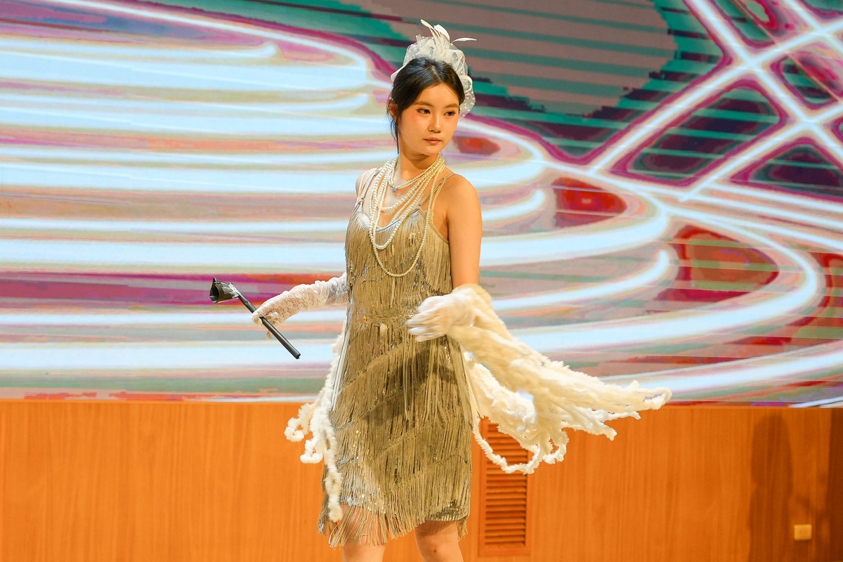 A Hong Kong student designed a shawl, headpiece, and fringe dress using old pillows, scrap fabric, and plastic ties, earning the Best Creativity Award.Image
