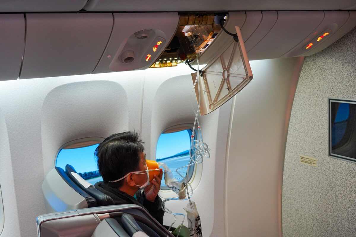 客艙失壓模擬，乘客戴上氧氣面罩，緊急逃生演練十分逼真。