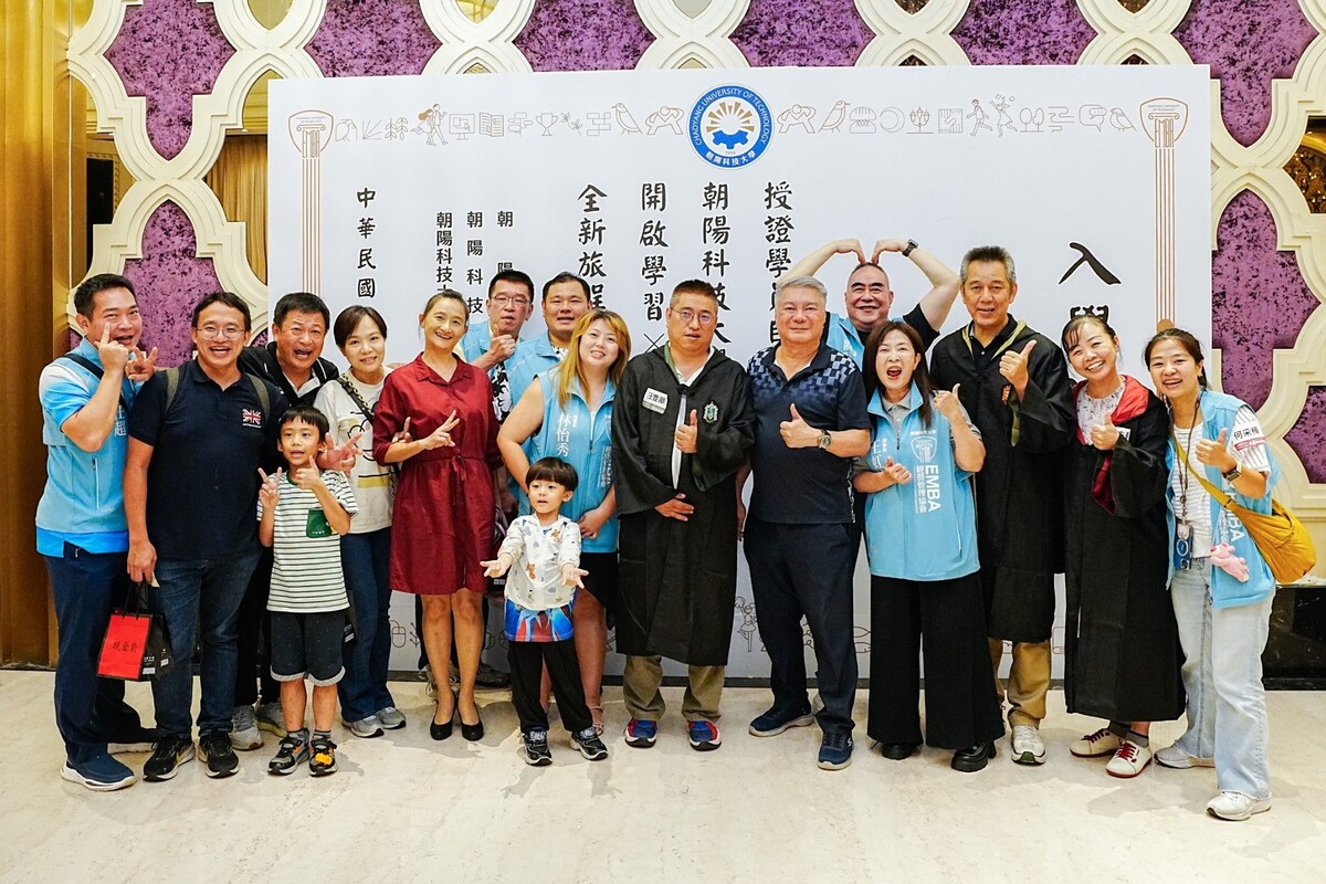 會場巨型入學證書打卡牆，吸引EMBA新生與師長開心合影。圖片